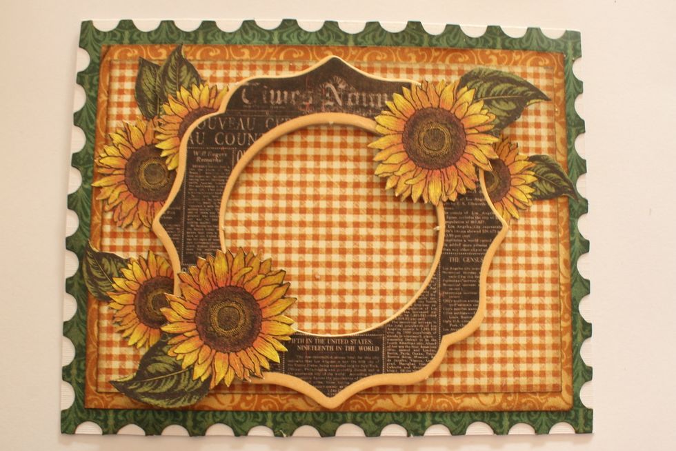 Cut out two more sunflowers and attach them on top of the chipboard frame in the left lower and right upper corner.