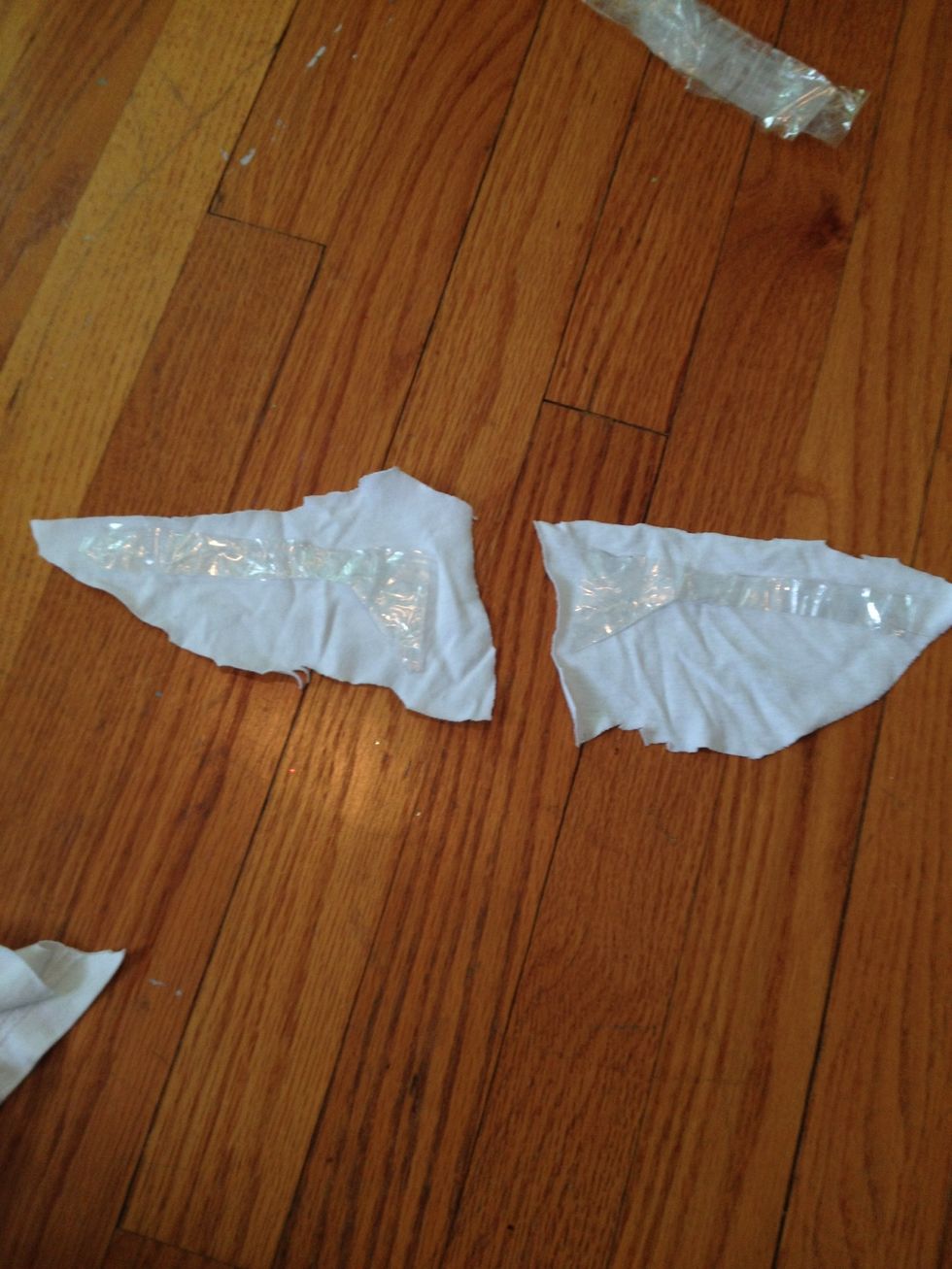 Cut out two triangular-ish pieces of white fabric and line them up with the tape shapes, underneath them.
