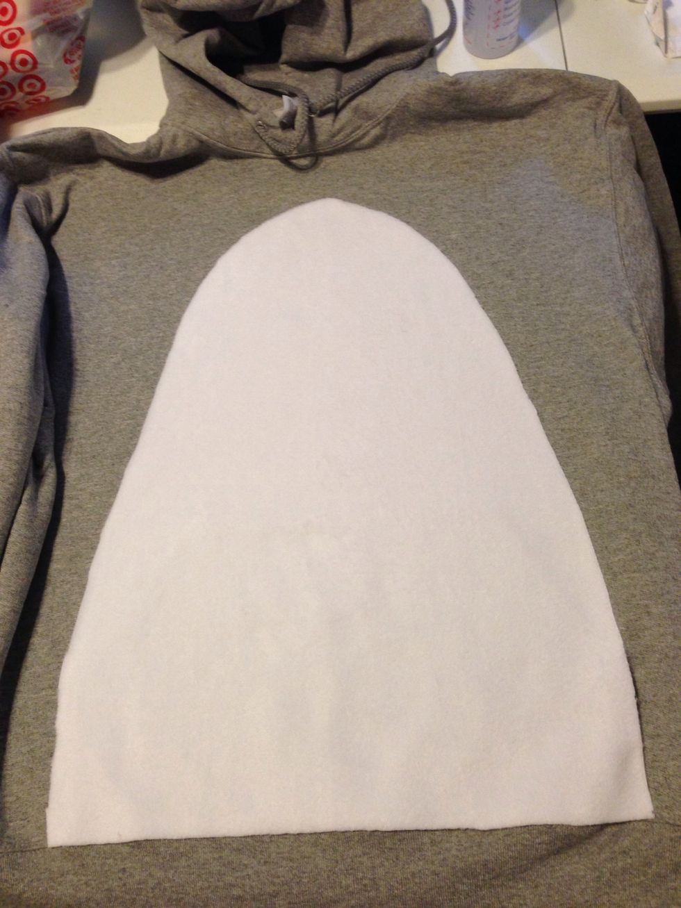 Cut out ur white fleece & it should look like this :3 the bottom aligns with pocket seam. This will be like a ruler to keep the bottom straight. Have the top point in the middle of the neck