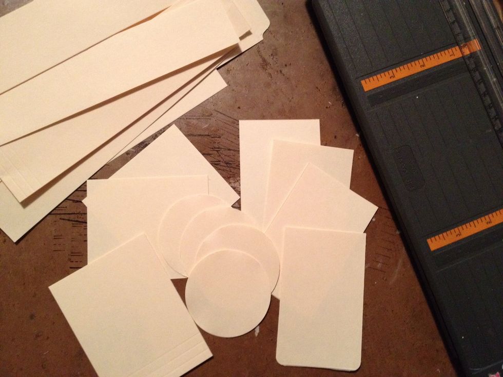 Cut paper/paper scraps into desired tag shapes. Standard shipping tags measure 2 1/4 x 4 1/4. I cut a variety of sizes close to this standard measurement. I punched a few large circle tags too.