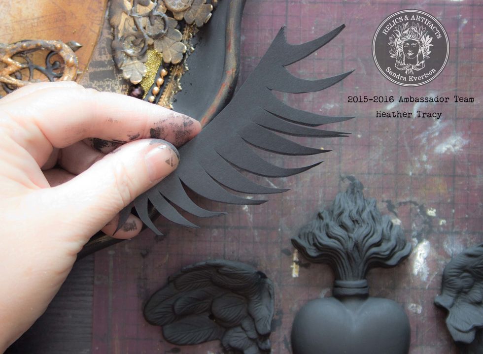 Cut plain black card-stock into feathery shapes that mimic the curve along the sides of the frame: