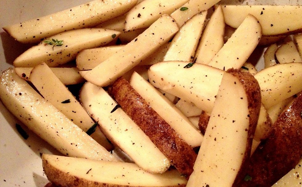 Cut potatoes into small wedges - think steak fries. The bigger the pieces, the longer the cooking time! Toss in a large bowl with 1 tbsp olive oil & the herbs you reserved. Of course, salt/pepper too.