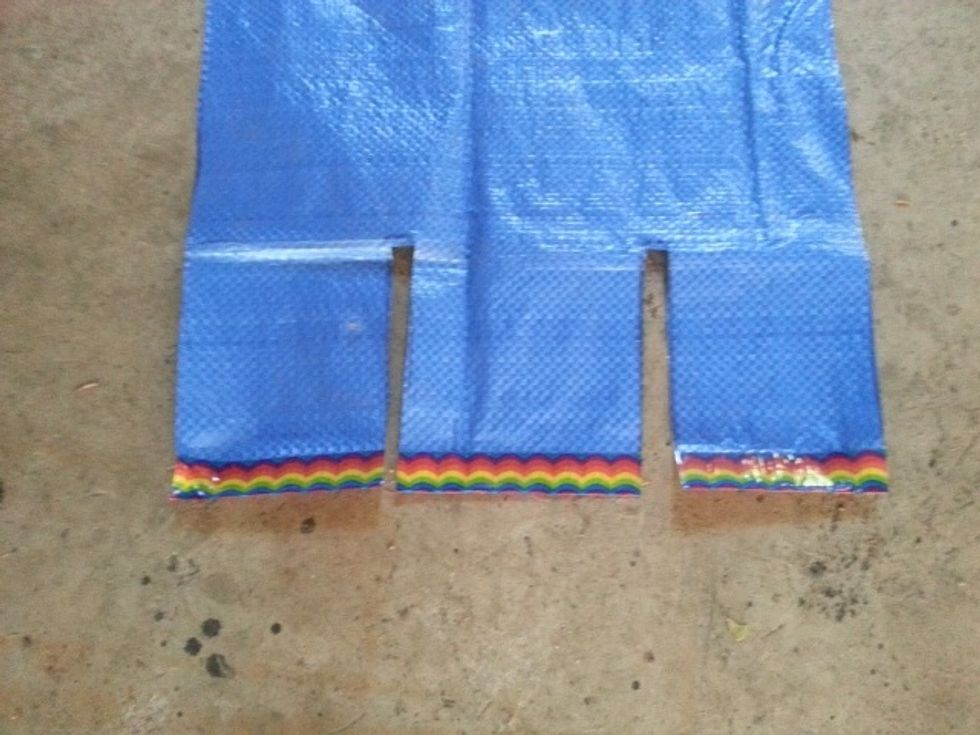 Cut slits approx 1/2" wide by the height you would like to have your pockets. Fold the tarp up to the crease you made earlier and tape each slit as well as the edges to make pockets.