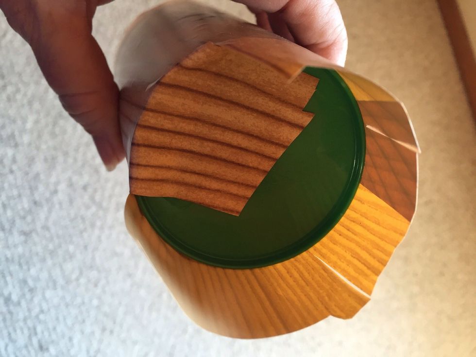 Cut slits every inch along paper that is sticking out on top and bottom of cup.  Fold pieces down, sticking to bottom of cup & inside of cup.