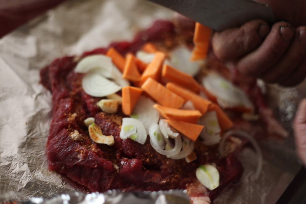 Cut some of the vegetables from the first steps you wish to use into smaller pieces and place them over the top of the meat with the chopped onions.