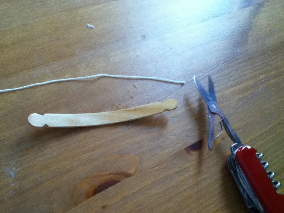 Cut string so that it goes 2 inches past length of stick.