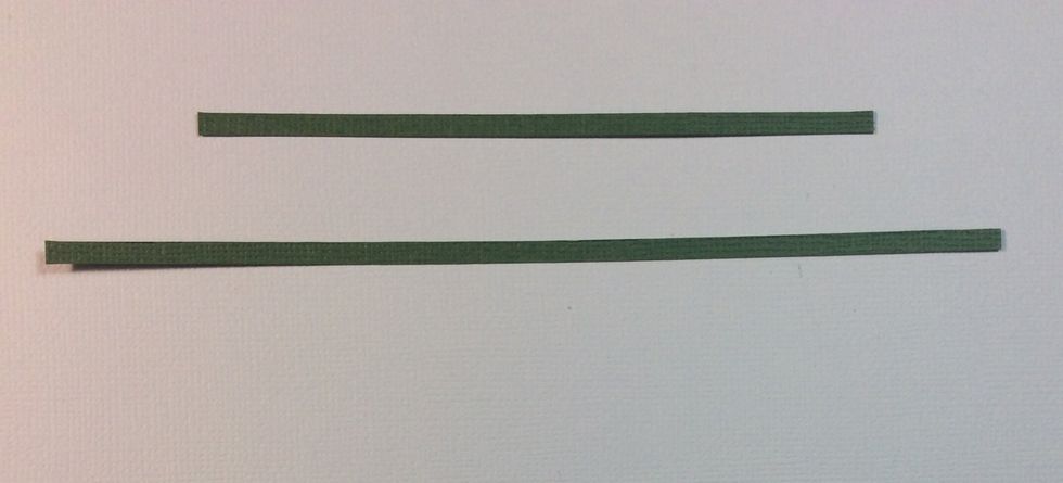 Cut strips of card stock approximately 1/8 inch wide and to the length and breadth of the cross of chipboard, ink edges if desired .