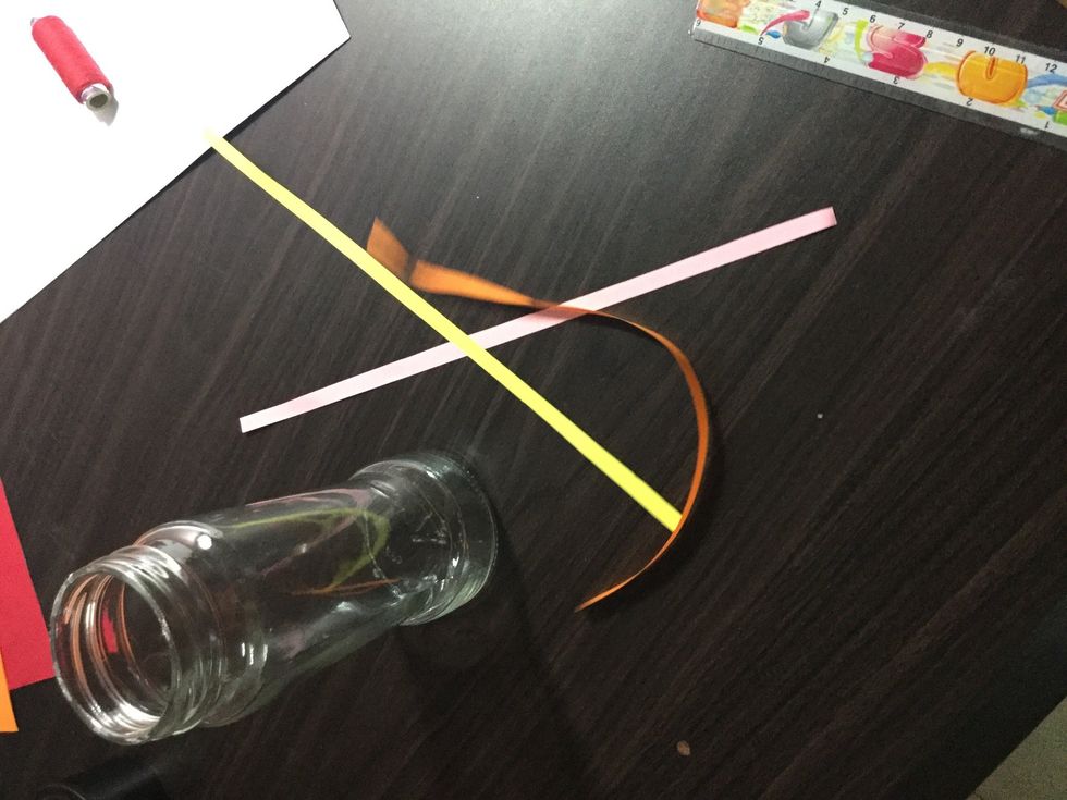 Cut strips of different colour papers and paste them on the bottom of the jar with glue