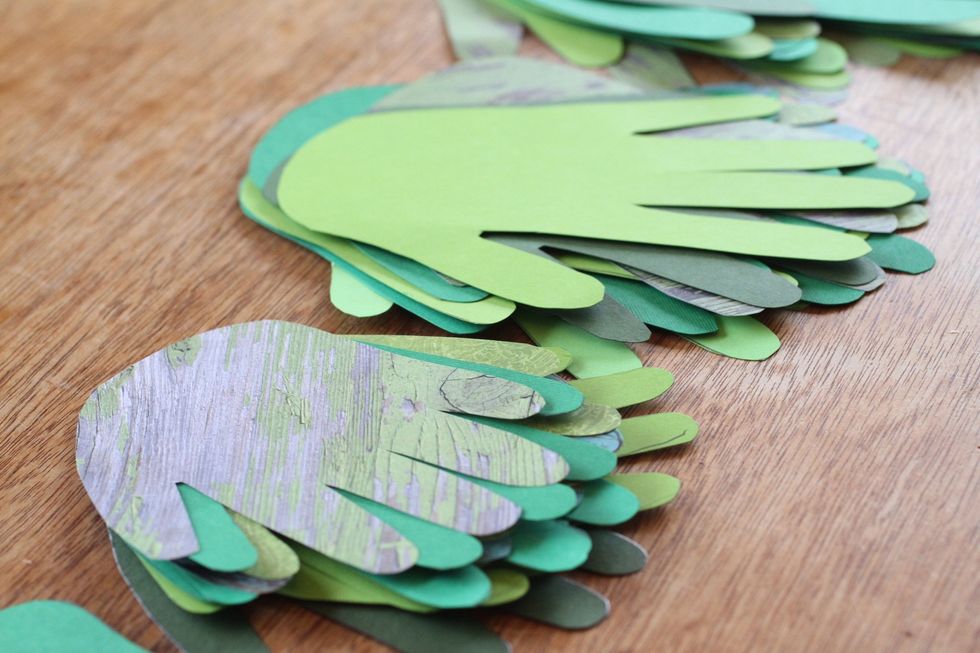 Cut that outline out and repeat the process until you have 12 green handprints.