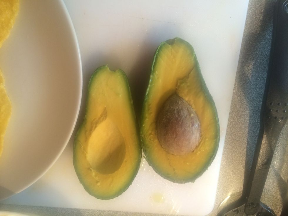 Cut the avocado in half.
