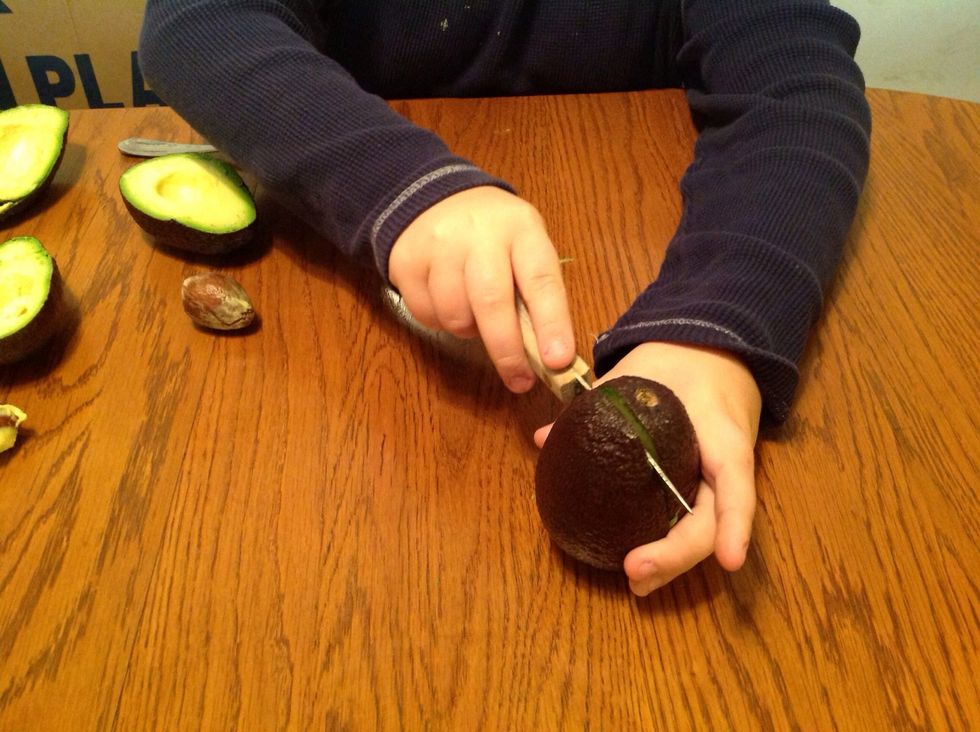 Cut the avocados in half.