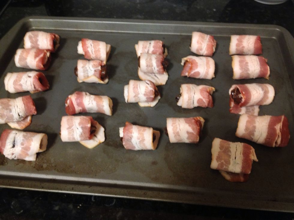 Cut the bacon strips in half. Wrap each date with 1/2 strip of bacon. Place them on a baking sheet (with rims). Name for this appetizer: devils on horseback.