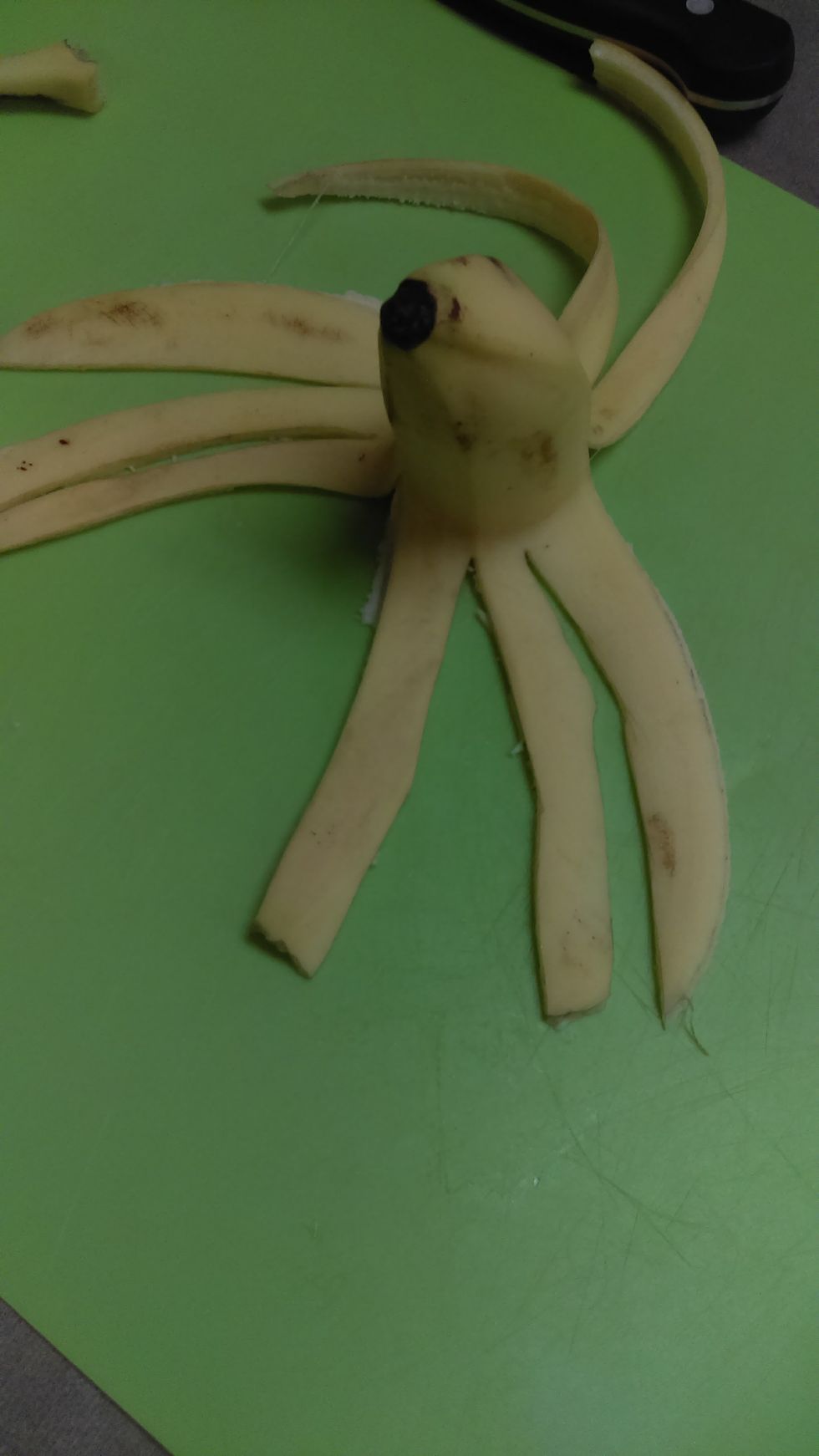 Cut the banana peel into eight octopus arms.