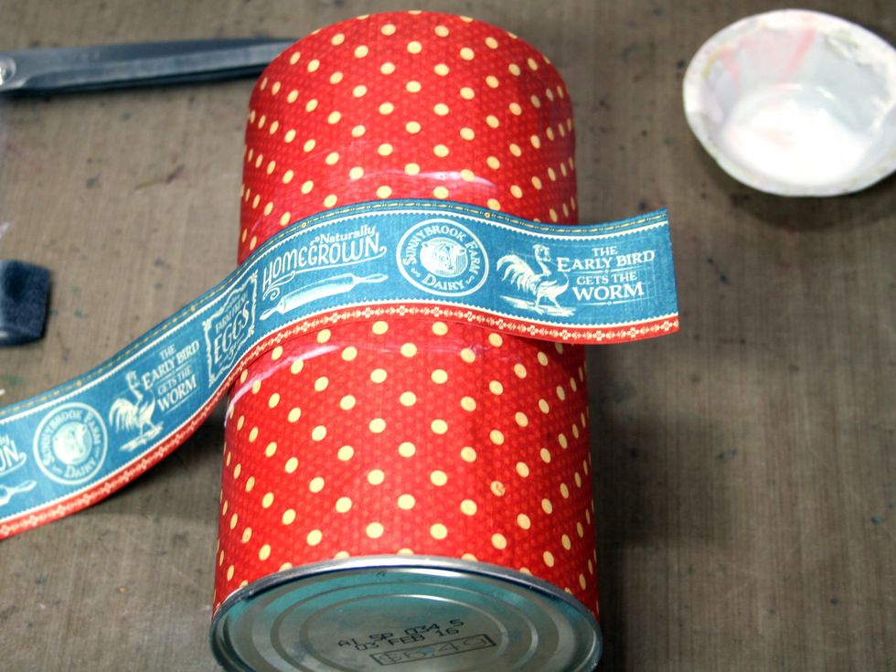 Cut the border shown in the photo from Country Life and adhere with matte medium.  Be sure to apply the medium to both the can and the paper strip.