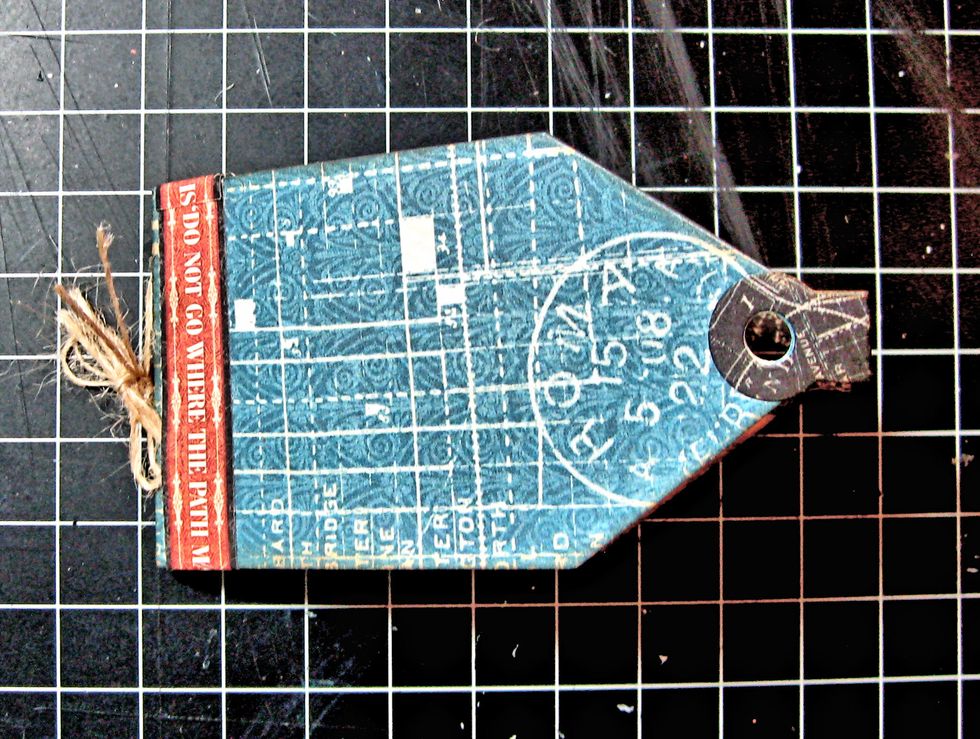 Cut the border strip from the 8x8 papers and glue on the left hand side of the mini tag book. I wrapped it all the way around the outside and continued through the inside.