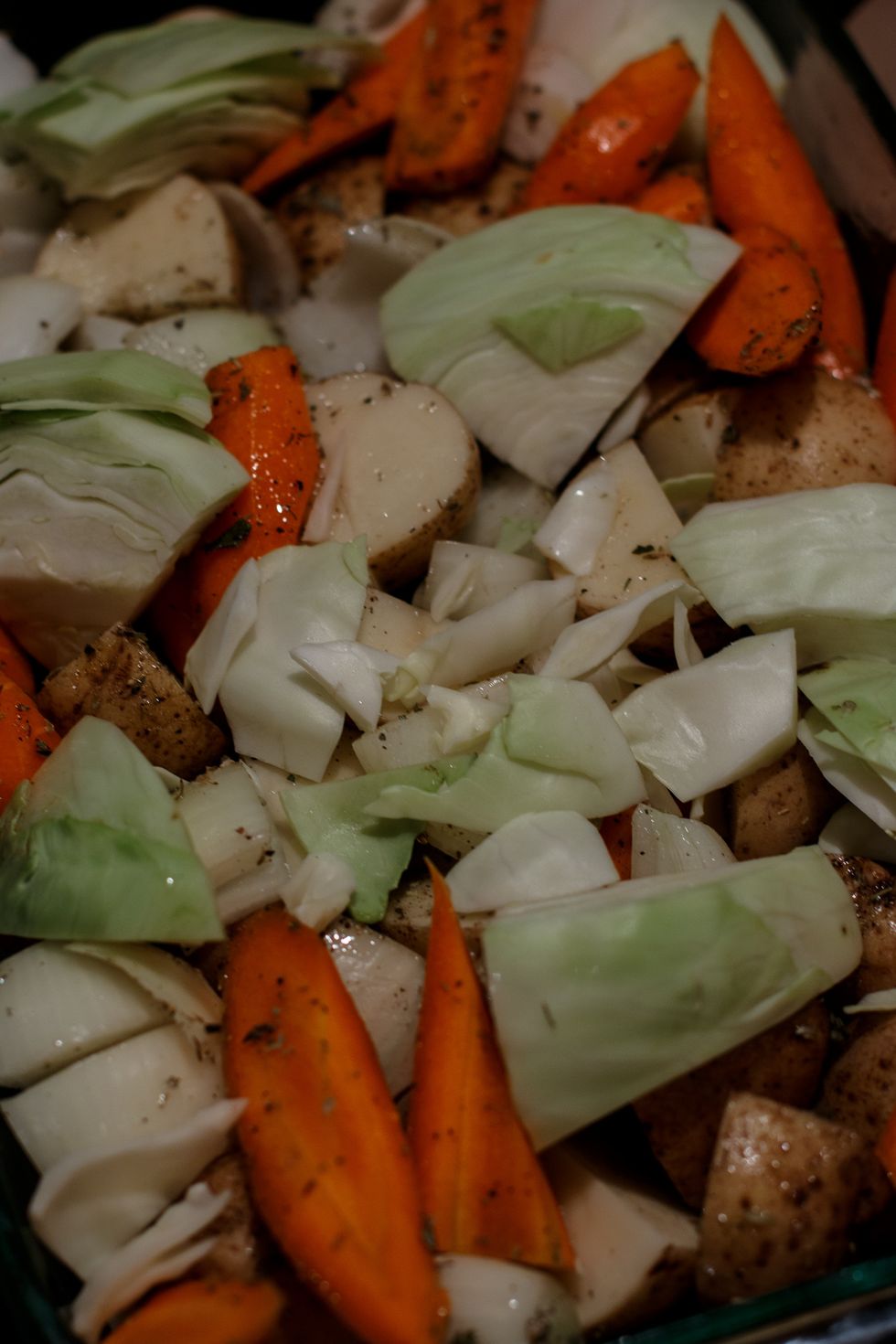 Cut the carrots, potatoes, remaining onions and cabbage into large chunks. Coat with olive oil and season with the herbs and spices. Place this into the oven with the pork.