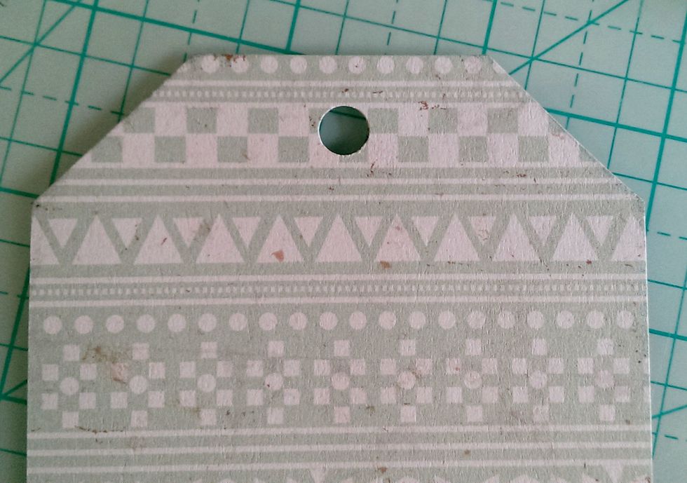 Cut the corners off, and punch a hole at the center point.