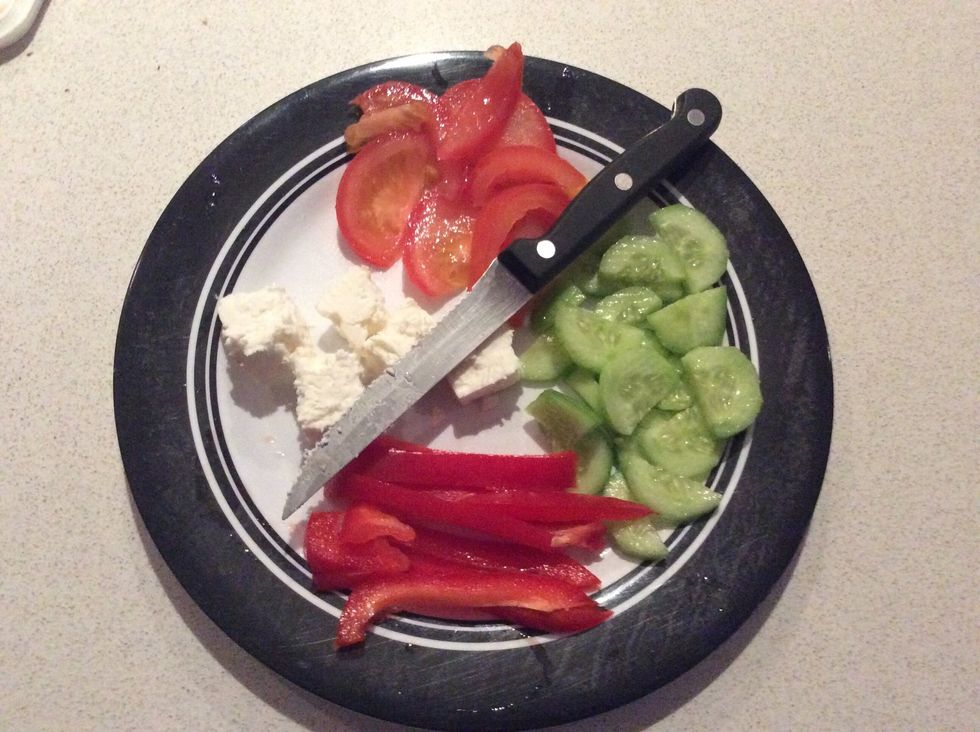 Cut the cucumber, tomato & capsicum in small pieces. Unless you want them bigger or smaller, it's your choice. With the feta you can simply break it into how many pieces you want to with your hands.