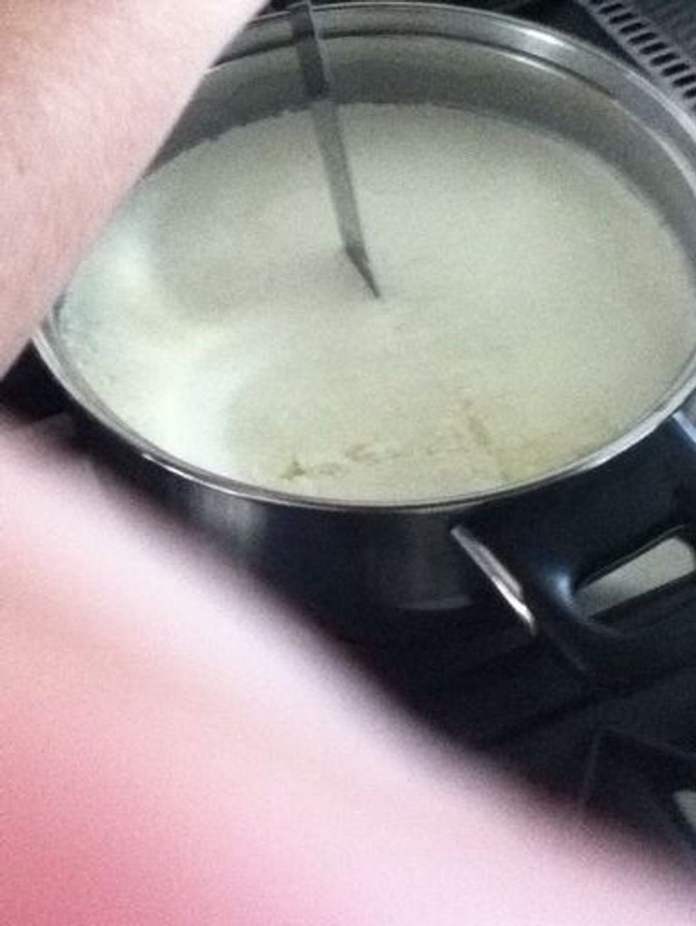 Cut the curd using a knife that reaches to the bottom of pot. First cut into strips about 2 centimetres wide, then do the same over the original cuts. Then make cuts on an angle as the confines.
