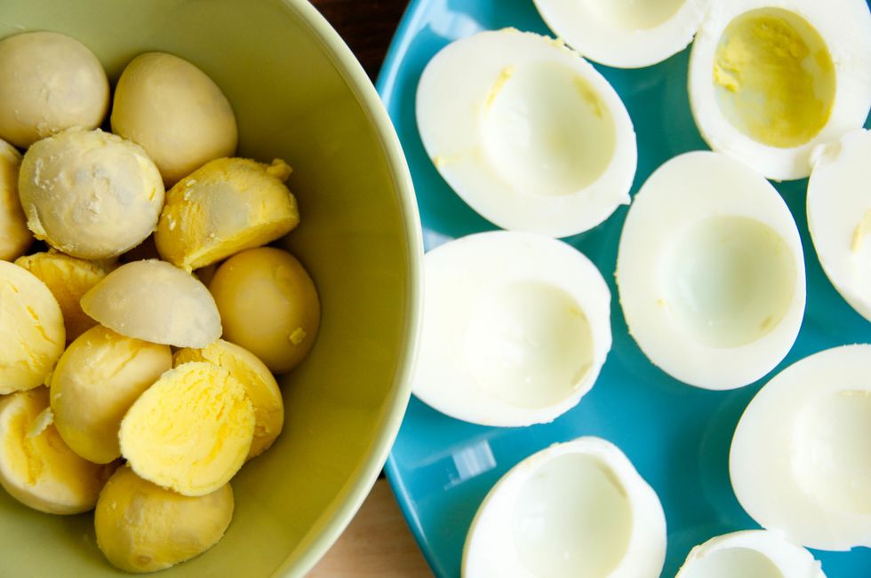 Cut the eggs in half, remove yolk and place them in a bowl.