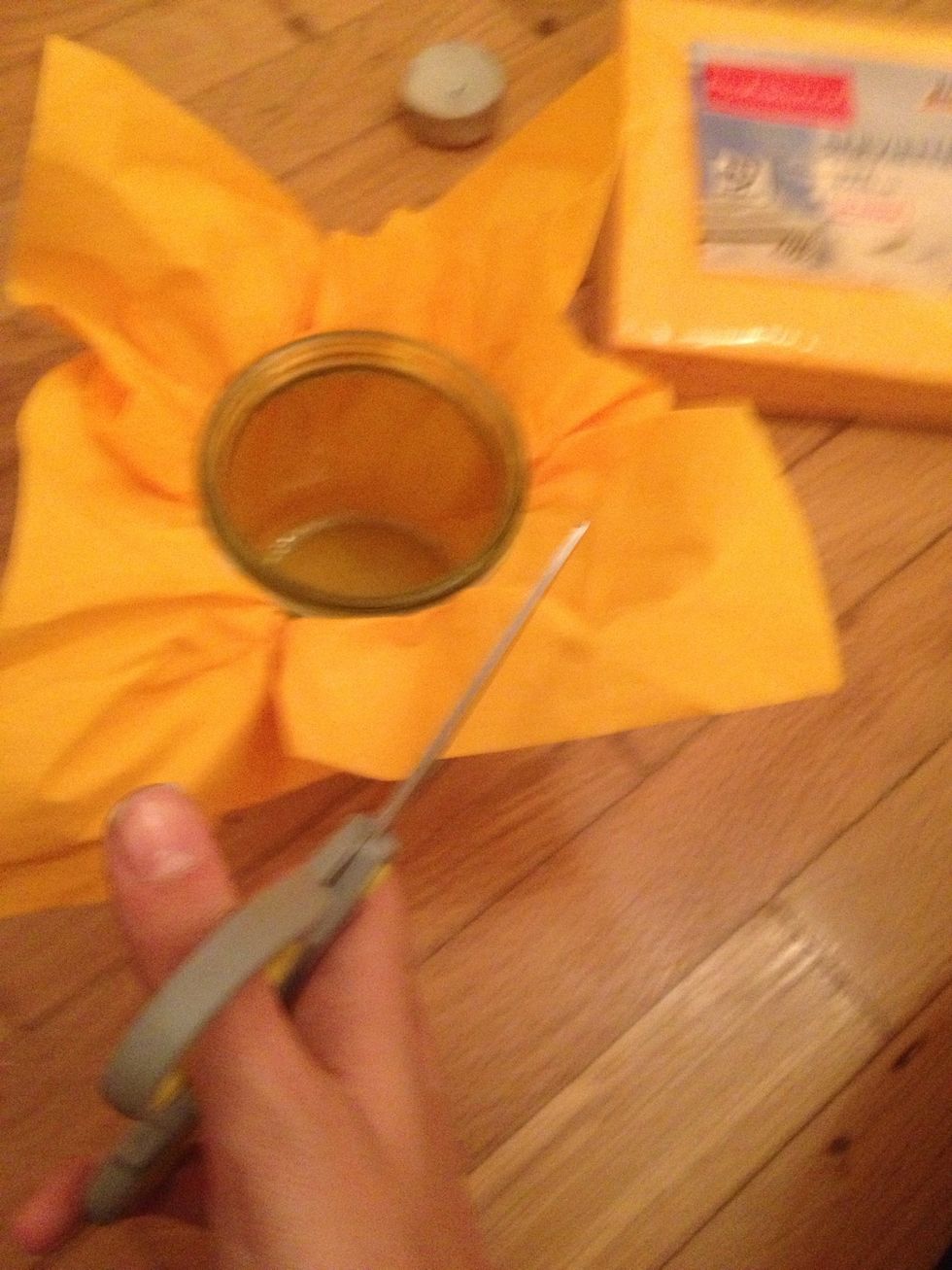 Cut the ends of the napkin where it goes beyond the jar.