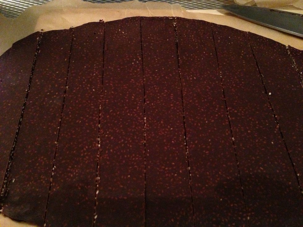 Cut the enormous cookie on the sheet. (You can take it out a bit earlier for easy cutting and then put it back in the fridge before you remove them from the paper)