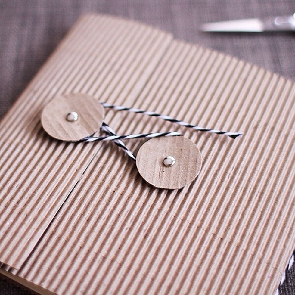 Cut the extra cardboard paper into a circle to use for the rings outside of the album. Trim down the inside pages to be 10\u2033 x 5\u2033.