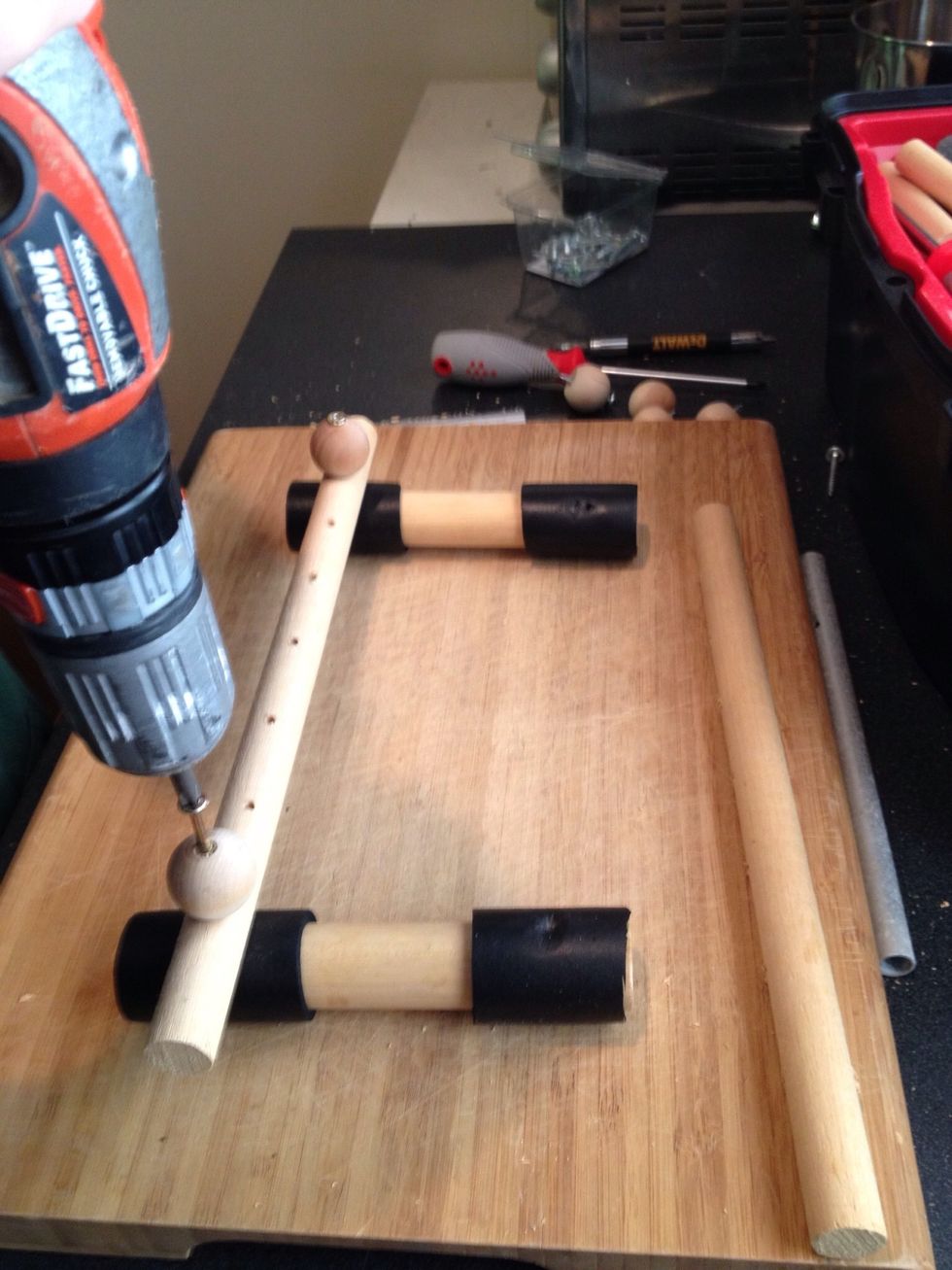 Cut the foam sleeve into 4 pieces and slide onto the legs of  the xylophone. Drill the screw through the ball knob and the base dowel rod-into the legs.