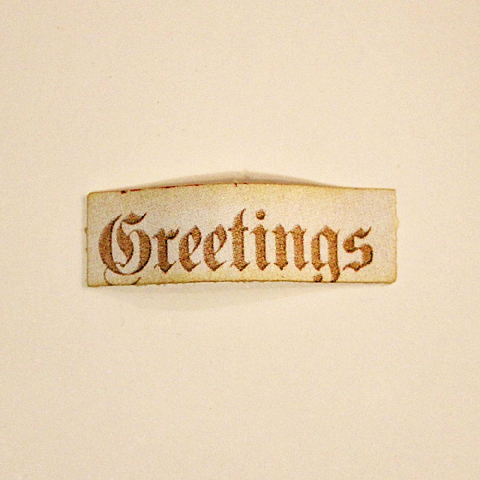 Cut the "Greeting" sentiment from the from the sheet which contained the circular image used earlier. Ink edges and adhere to the lower right side of the card.