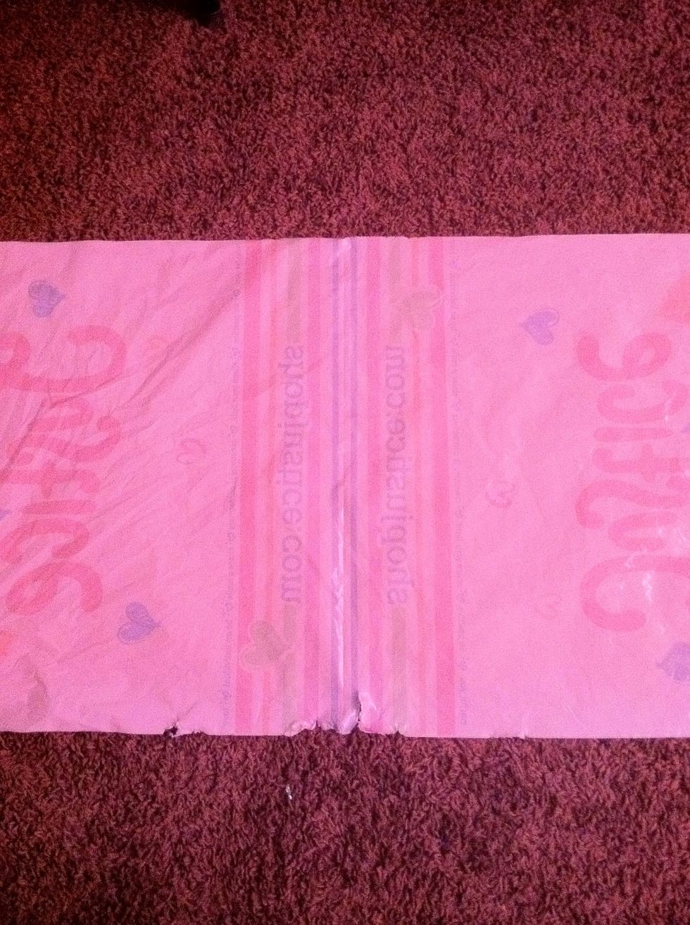 Cut the handles of a bag and cut down both sides to make it flat