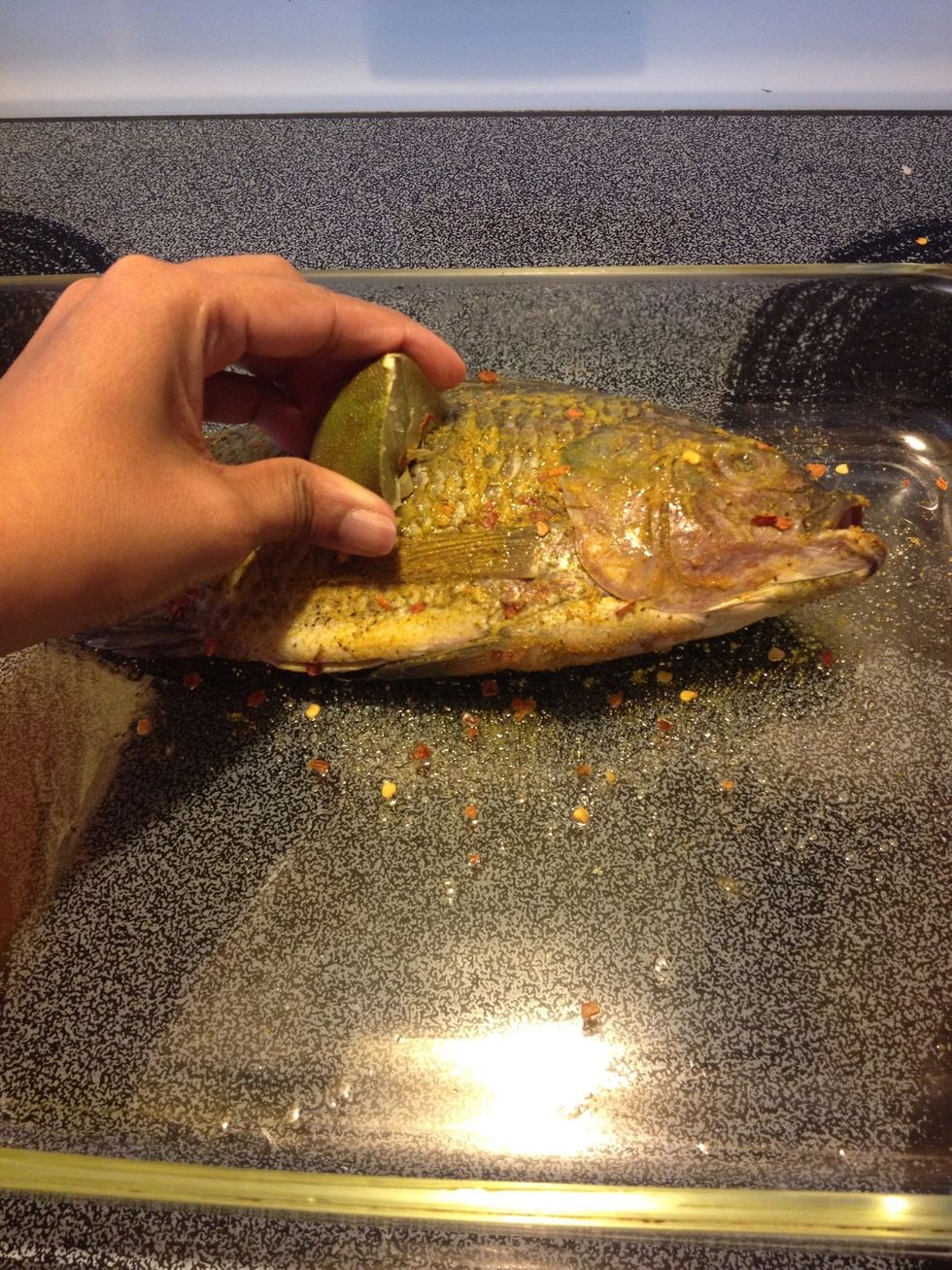 Cut the lemon into 4 pieces. Coat one piece with the spice mix and rub it all over the fish; stuff a little bit between the slits. Squeeze the lemon as you rub the fish.