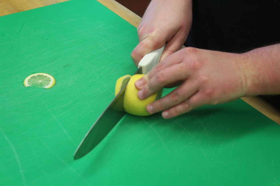 Cut the lemon into thin slices.