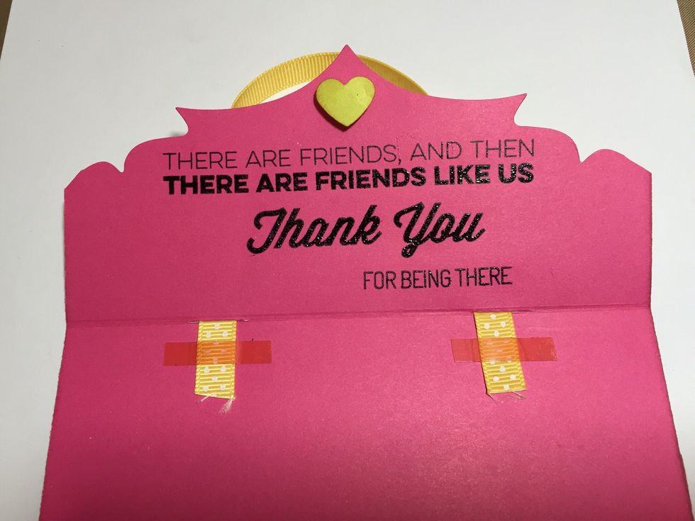 Cut the length of the ribbon and adhere it with strong red tape. Adhere the magnet on top of the caption as well
