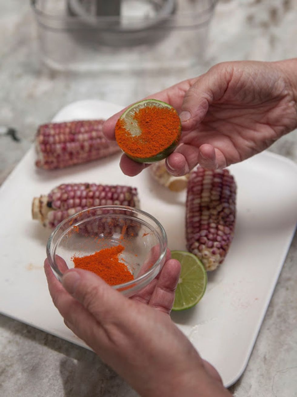 Cut the limes in half. Put the Kashmiri chili in a small bowl. Dip the halved limes into the chili.