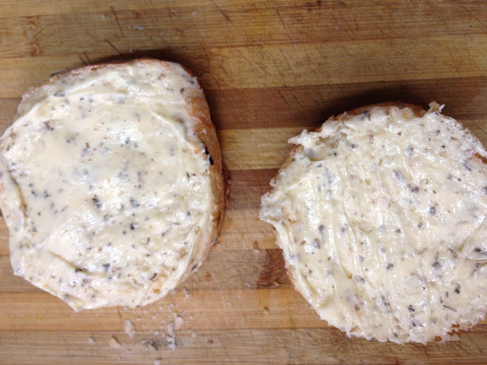 Cut the loaf half and spread the prepared butter liberally .
