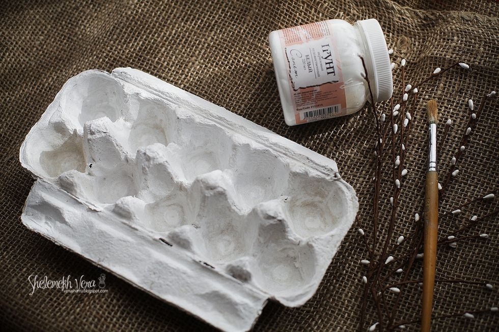 Cut the lower part of an empty egg container, wash in soapy water to remove germs, dry and cover it with white gesso. Use paper container as gesso doesn't stick to plastic very well.