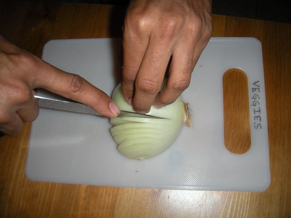 Cut the onion as close as possible to the root. Use 3 fingers: 1 in front, 2 behind. Tuck in the tip of your fingers & Move the blade along your front finger. This will keep you from cutting yourself.