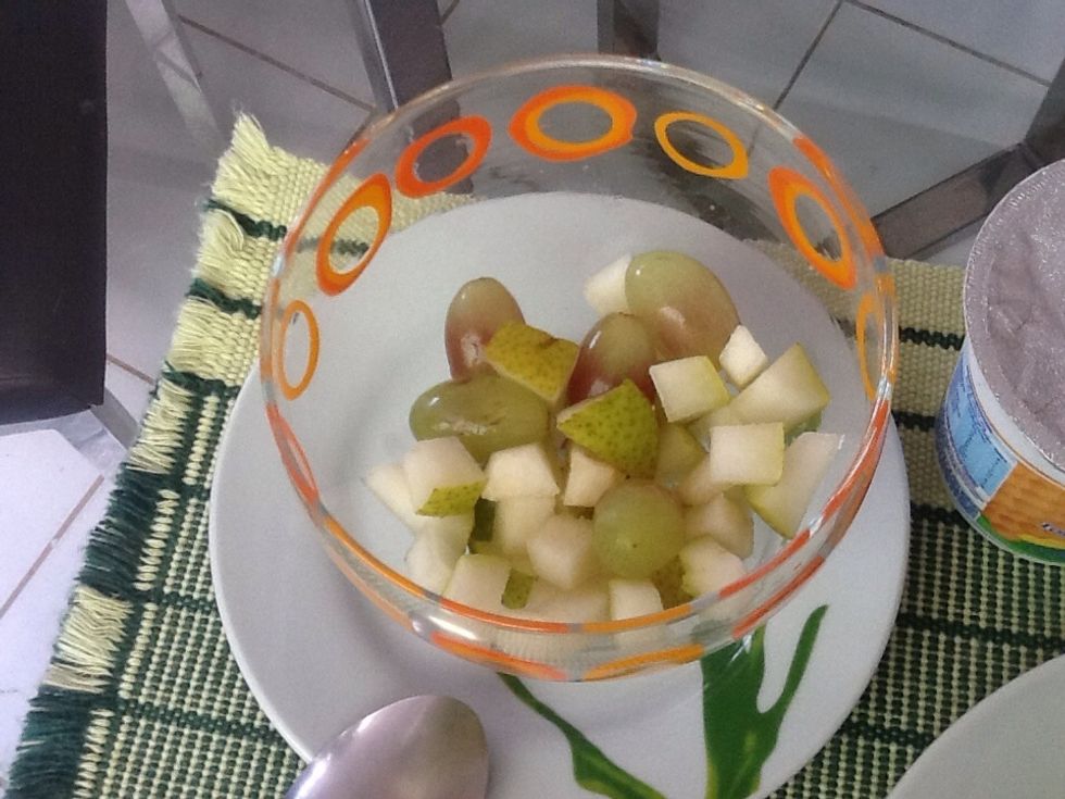 Cut the pear in cubes (or only small enough pieces for you to eat) and put it together with the grapes into the bowl you are going to use to have your meal.