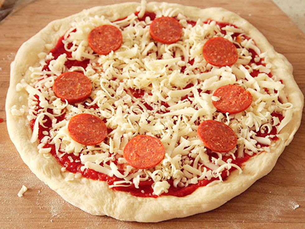 Cut the pepperoni stick into flat pieces then put the pieces all over the pizza it is your choice to add a lot of pepperoni slices or a small amount of pepperoni slices on your pizza