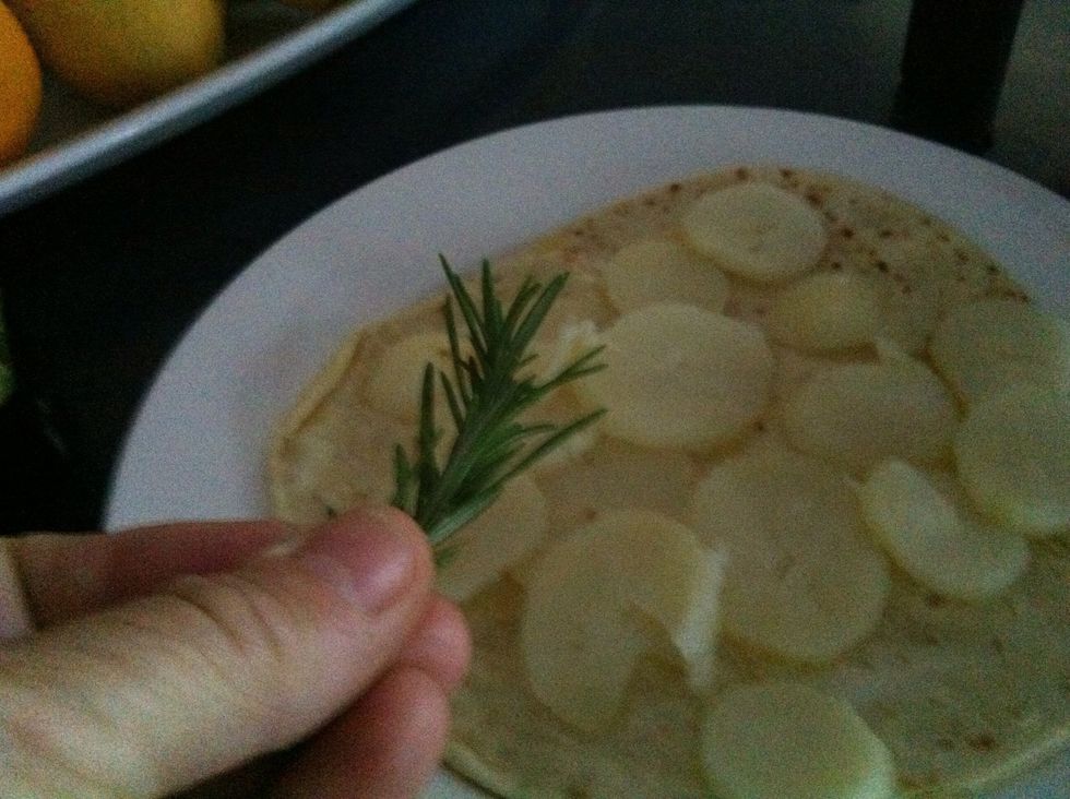 Cut the potatoes and put them onto the pizza base and sprinkle the rosemary on top
