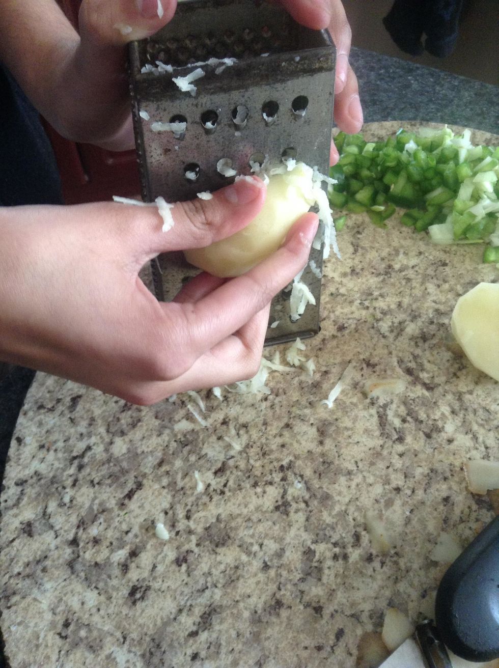 Cut the potatoes in half, to make the process of shredding the potatoes easier and simpler.