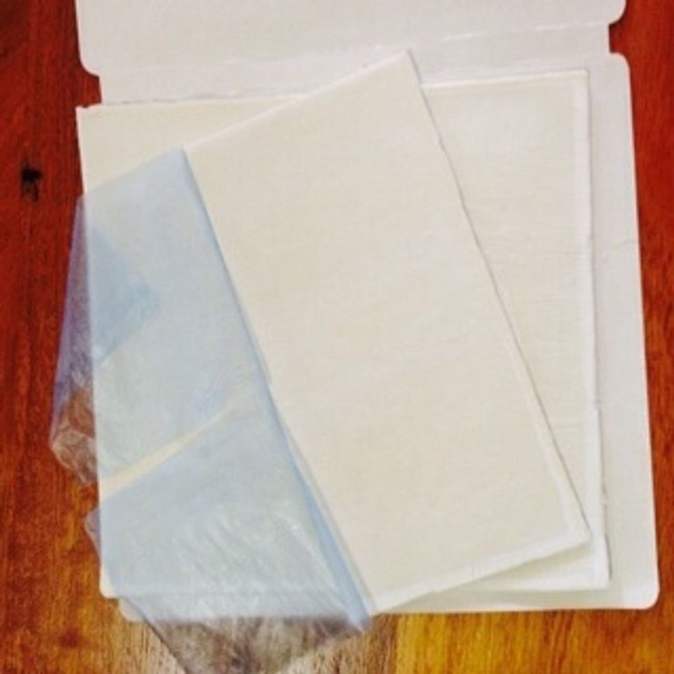 Cut the puff pastry into quarters to make squares, and dampen the edges of the pastry with water. Cut off any freezer burn.