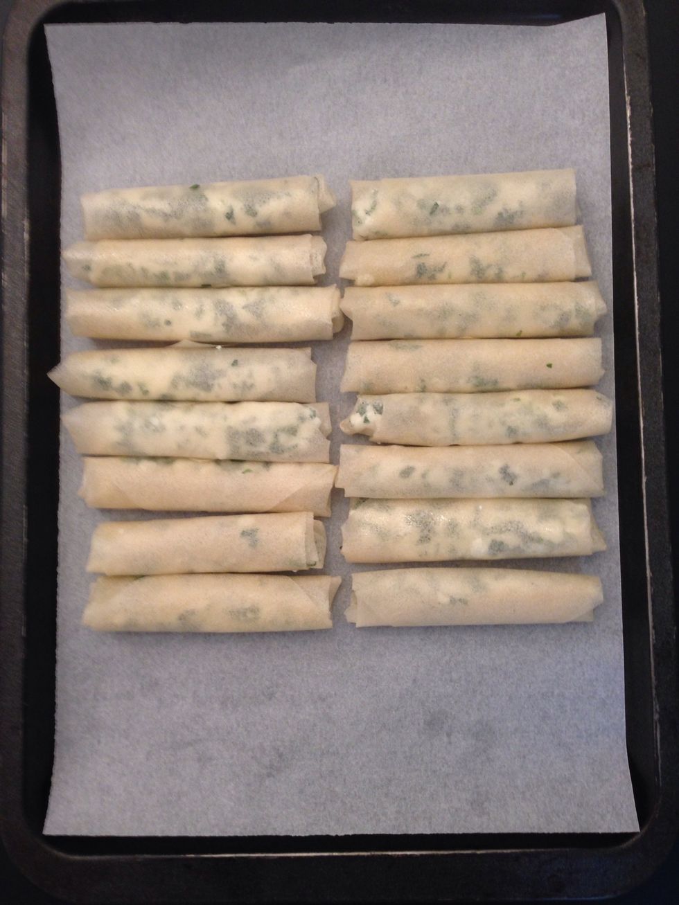 Cut the round sheets in 4 quarters. Spray with olive oil. Or baste with a brush. Roll garnish with the cheese-tarragon roll and put on the oven tray