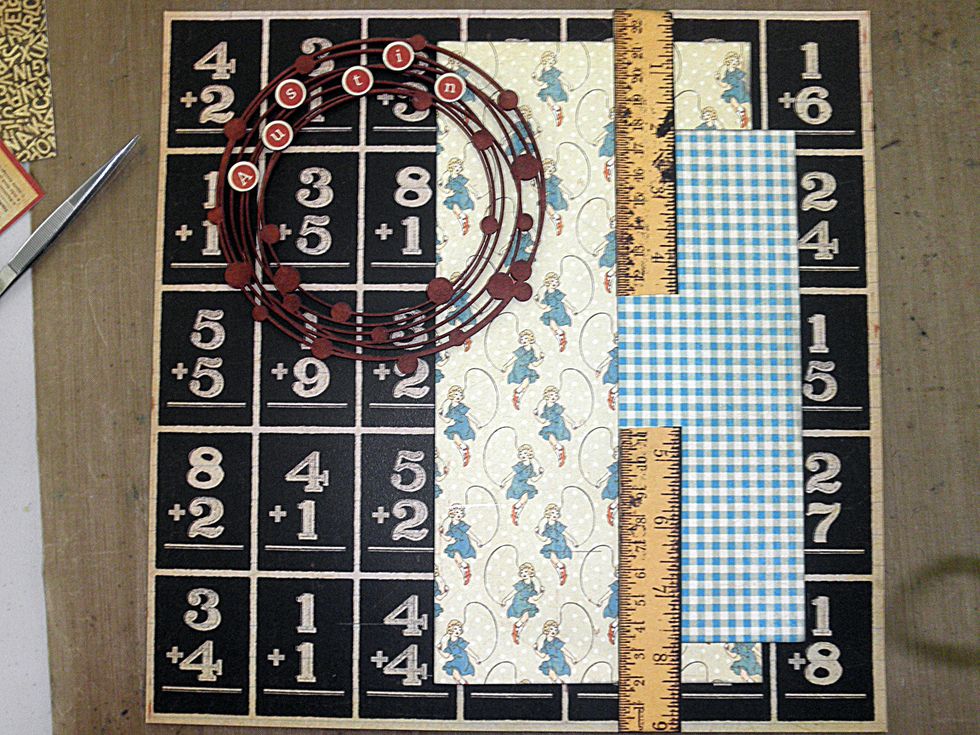 Cut the ruler in half and adhere as shown.  If you are using chipboard similar to what I have used, ink it with Distress Fired Brick and add alpha stickers from the sticker sheet.  (con't on next pg)