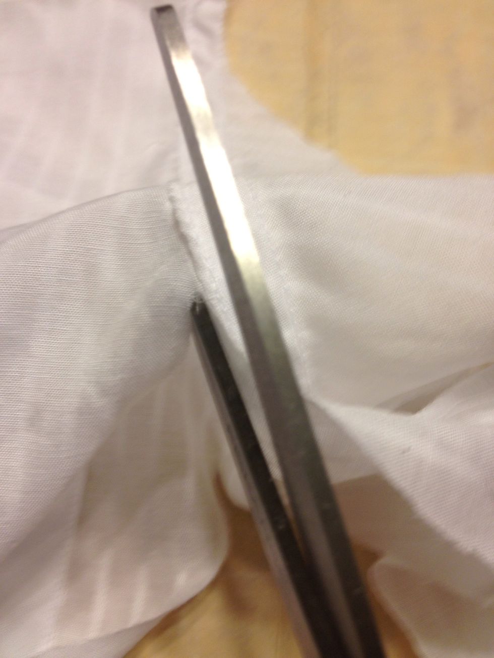 Cut the "sleeves" off along the inner edge. But slip your scissors in between the front & back to follow the edge better.