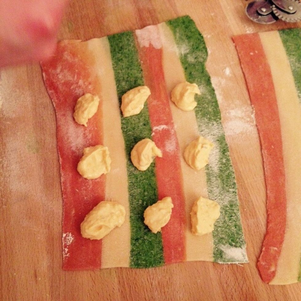 Cut the strip in two and start stuffing one half. Place 1/2 a teaspoon of stuffing at the center of each raviolo, considering an area of 4x4cm for each.