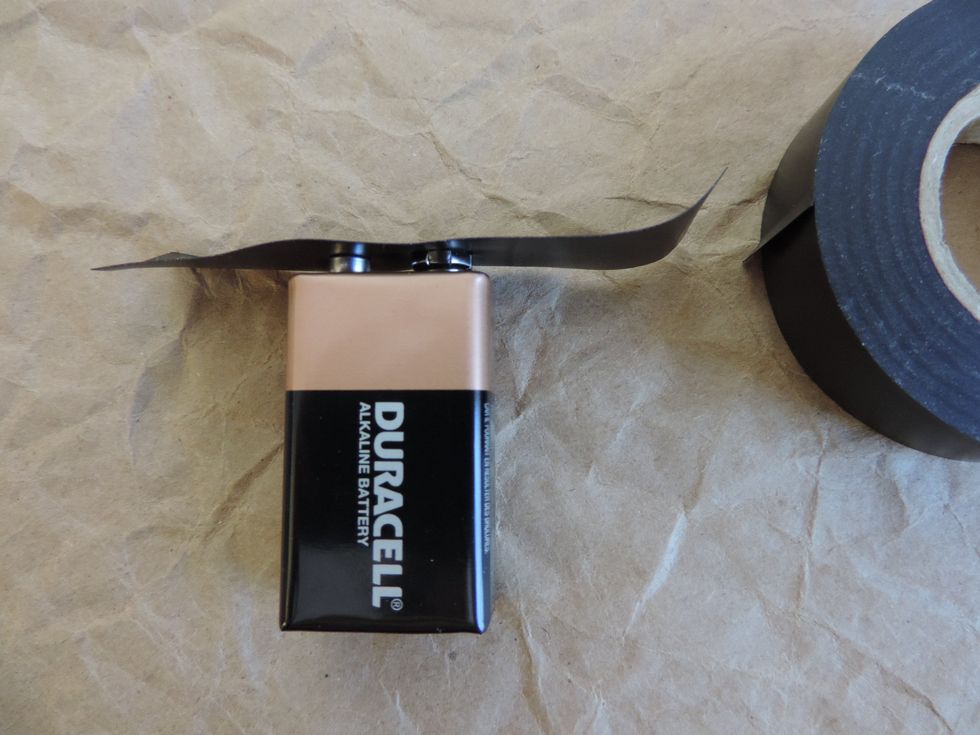 Cut the tape. Press the tape against the positive and negative clips. (The round shiny metal thingys that some people get conned into touching with their tongues and then soon regret.)