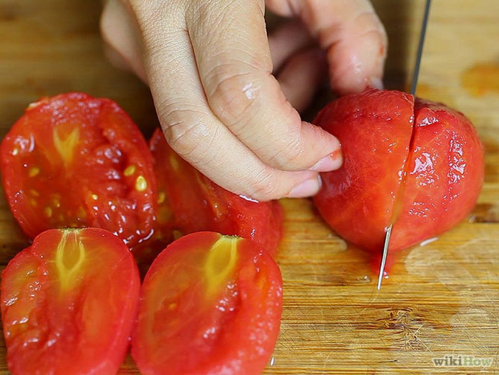 Cut the tomatoes in half and put them in the food processor to puree.