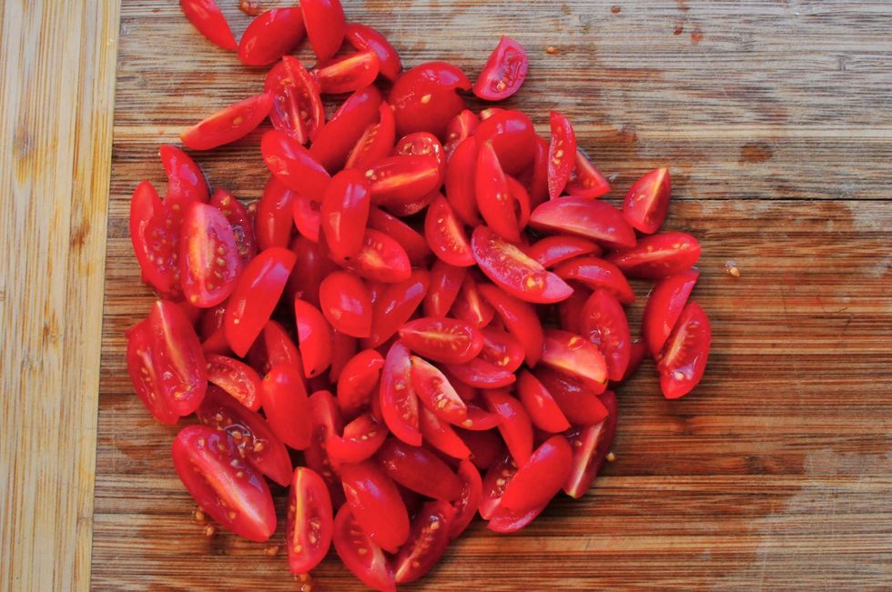 Cut the tomatoes in half if you are short in time.  Otherwise, cut them into quarters so everything is uniform with the potatoes.