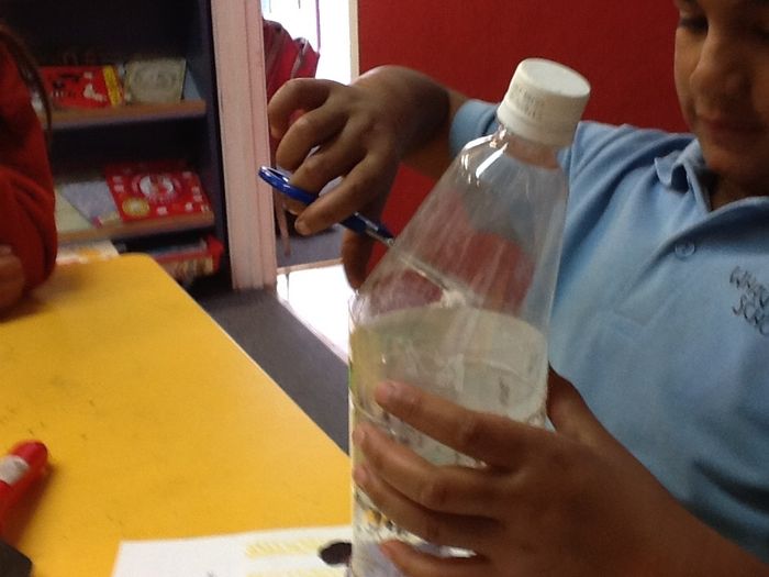 Cut the top off the large drink bottle.